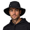 Junger Mann trägt leichten Regenhut von Alpin Loacker mit Kinnriemen, ideal für Outdoor-Aktivitäten, aus 100% recyceltem Polyester, wasserdicht und atmungsaktiv.