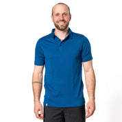 Model posiert in blauem Merino Coolmax Polo vor weißem Hintergrund
