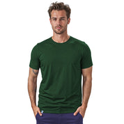 Merino Coolmax T-Shirt Herren 150 g/m2: Modell trägt dunkelgrünes Merino-T-Shirt mit Coolmax, ideal für Outdoor-Aktivitäten, temperaturregulierend und geruchsneutral.