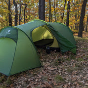 Tunnelzelt für 2 Personen 1.99kg im Wald aufgestellt, zeigt aufgerollte Frontklappe mit Schlafmatte innen und Wasserflasche draußen. Ideal für leichtes, funktionales Camping.