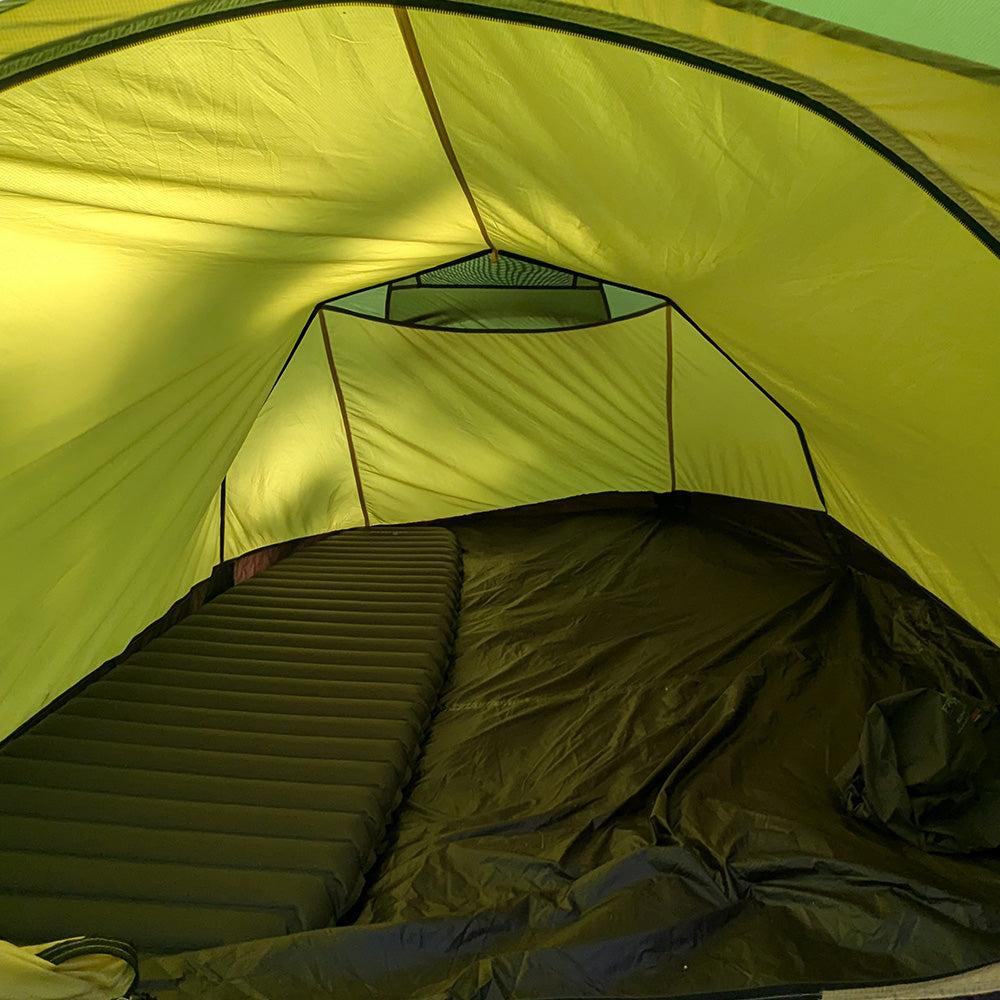 Tunnelzelt für 2 Personen 1.99kg: Innenansicht mit gelb-grünem Stoff, aufblasbarem Schlafpad und Mesh-Tasche, ideal für leichtgewichtige Outdoor-Abenteuer.