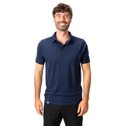 Mann trägt Merino Polo Shirt Herren, perfekt für Outdoor und Alltag, aus atmungsaktiver, temperaturregulierender Merinowolle. Elegantes Design, passend zu unterschiedlichen Anlässen.
