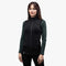 Frau trägt Merino Weste Damen 270g/m² über Langarmshirt, ideal als Midlayer für Outdoor-Aktivitäten. Sportlicher Schnitt, mit Seitentaschen und hohem Kragen.